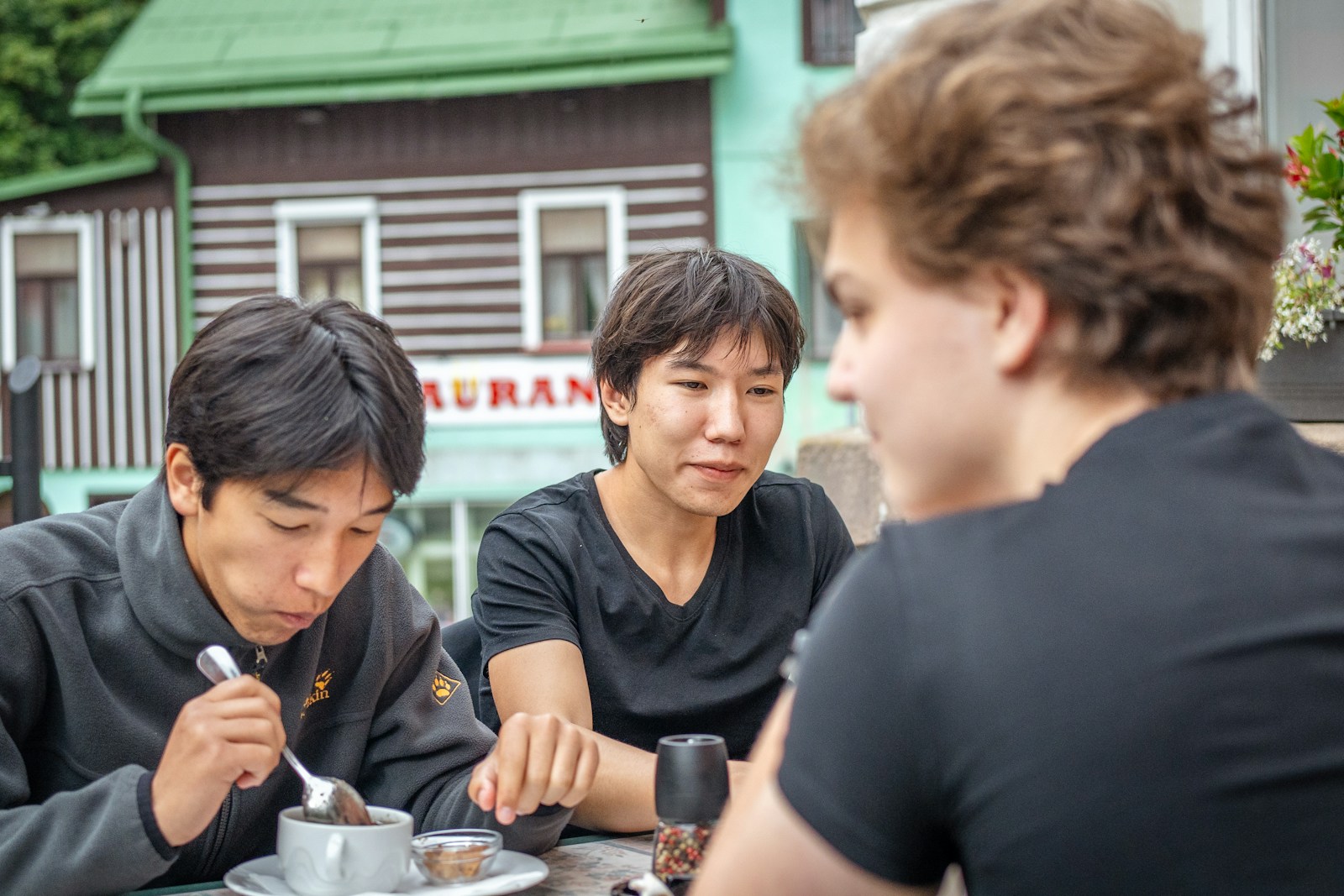 Three friends sharing a meal at an outdoor café